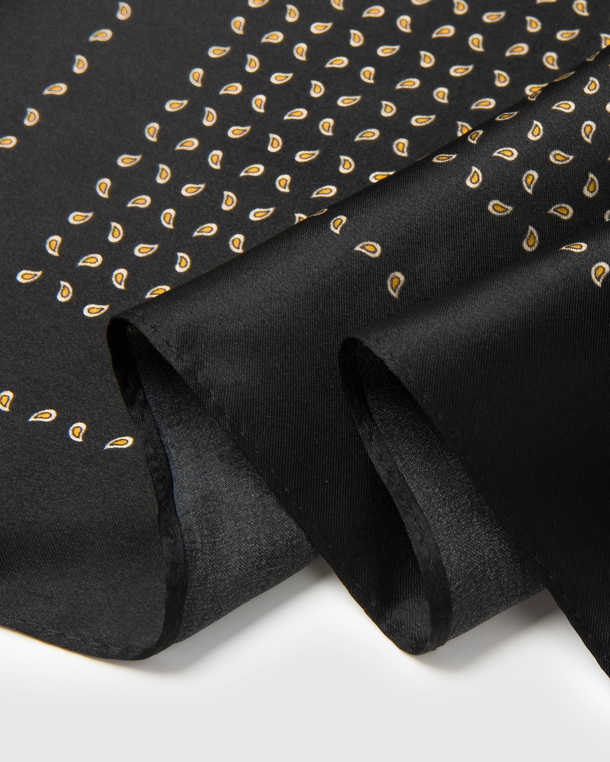 Close-up of the hand-illustrated gold paisley seeds with pale inner dots printed in archival ink on pure silk