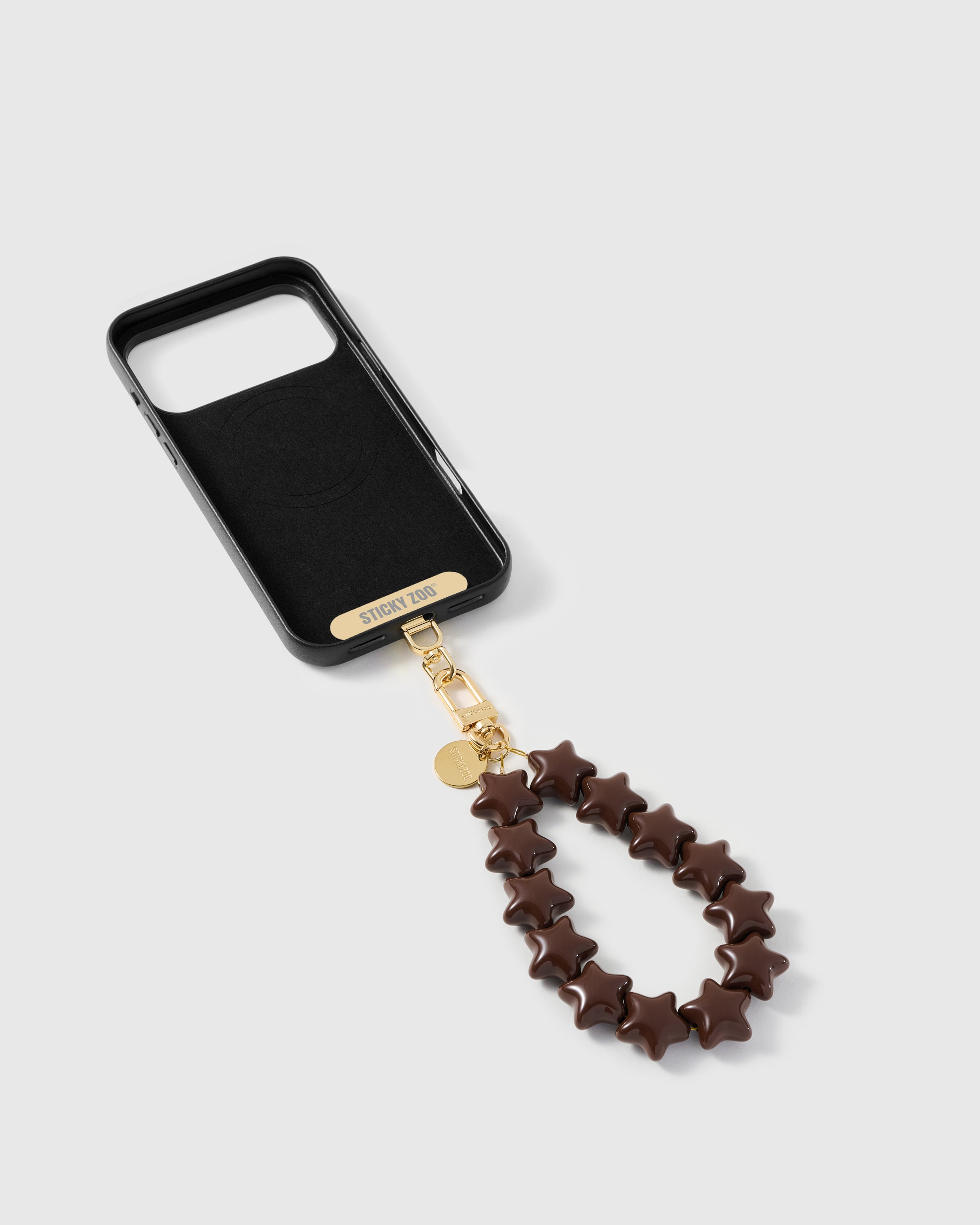 Phone Strap Card included — inside of phone case showing the STICKYZOO Phone Strap Card with cocoa star bead strap connected