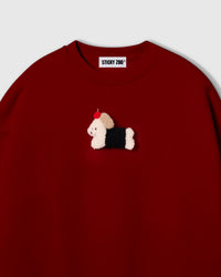 Close-up of plush dachshund in black coat with red apple on red cotton showing dimensional layered texture