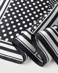 Close-up of the hand-illustrated polka-dot motif and double-stripe border printed in archival ink on pure silk