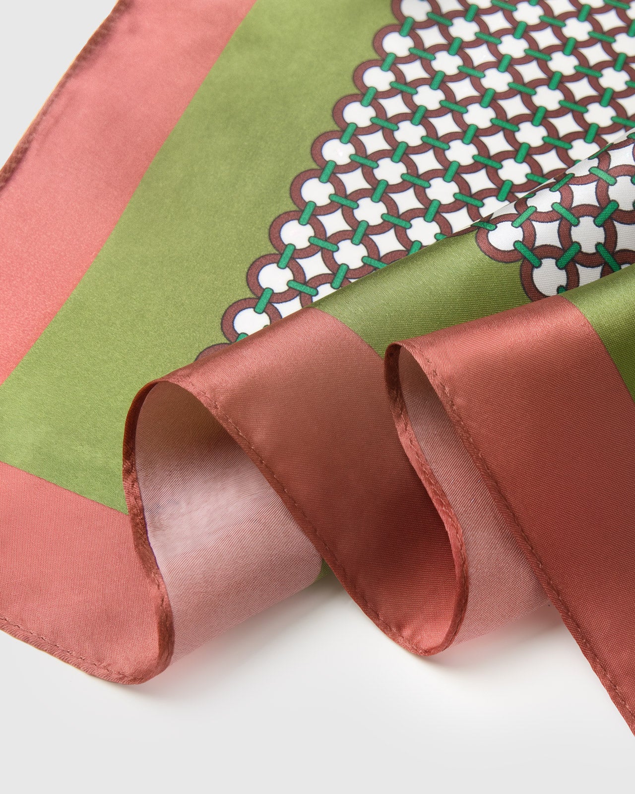 Close-up of the scalloped olive and rose border meeting the hand-illustrated tile mosaic motif on pure silk