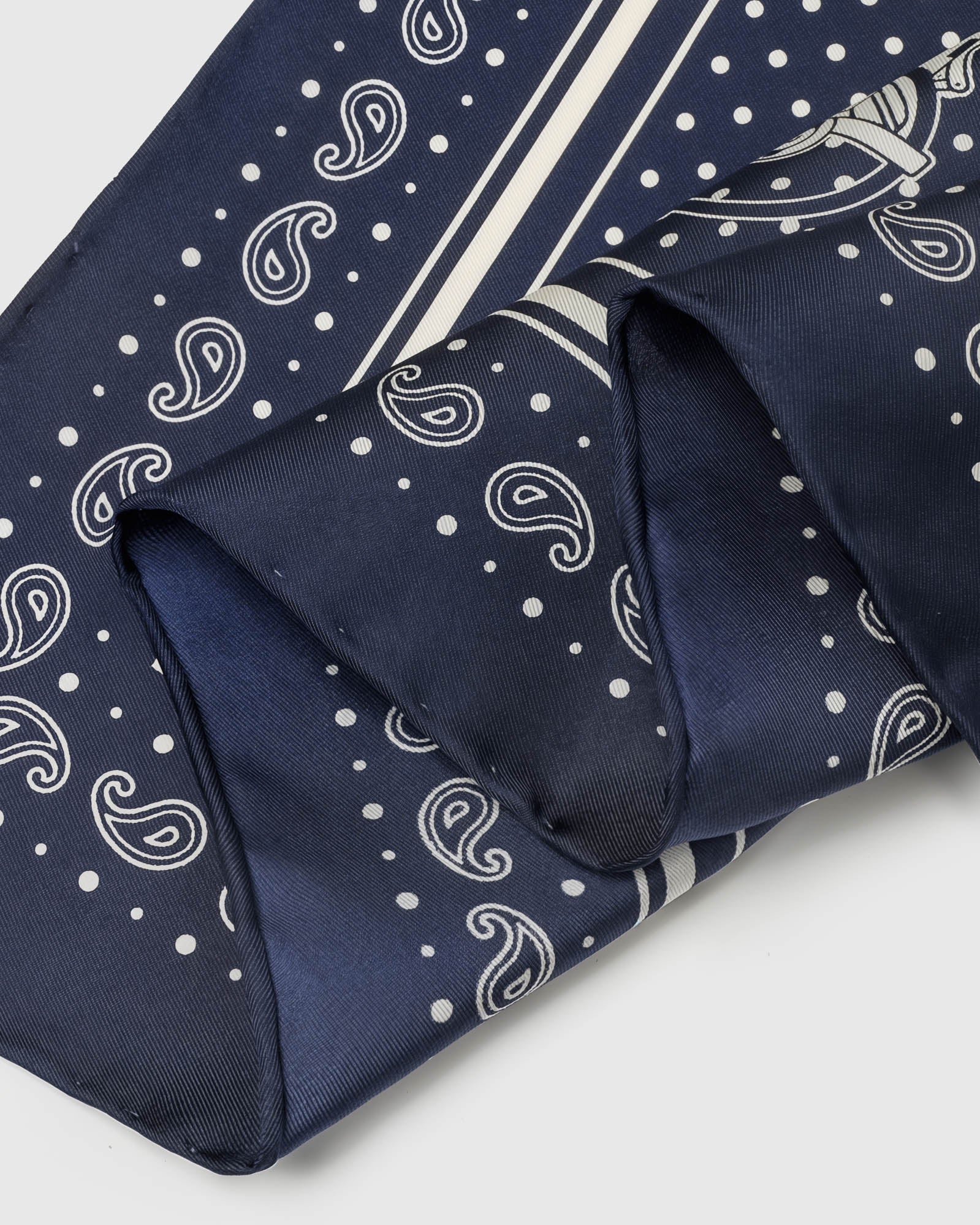 STICKYZOO navy bandana silk scarf folded into a triangular drape showing the carriage motifs around the border