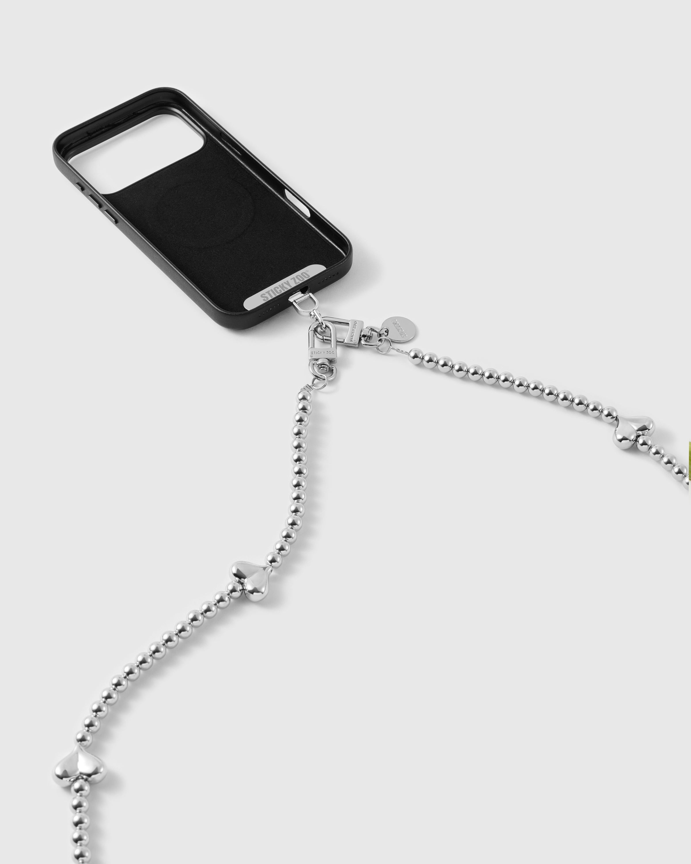 Black phone case with the silver-tone beaded strap attached, ball-bead chain and puffy heart beads falling in a long line.