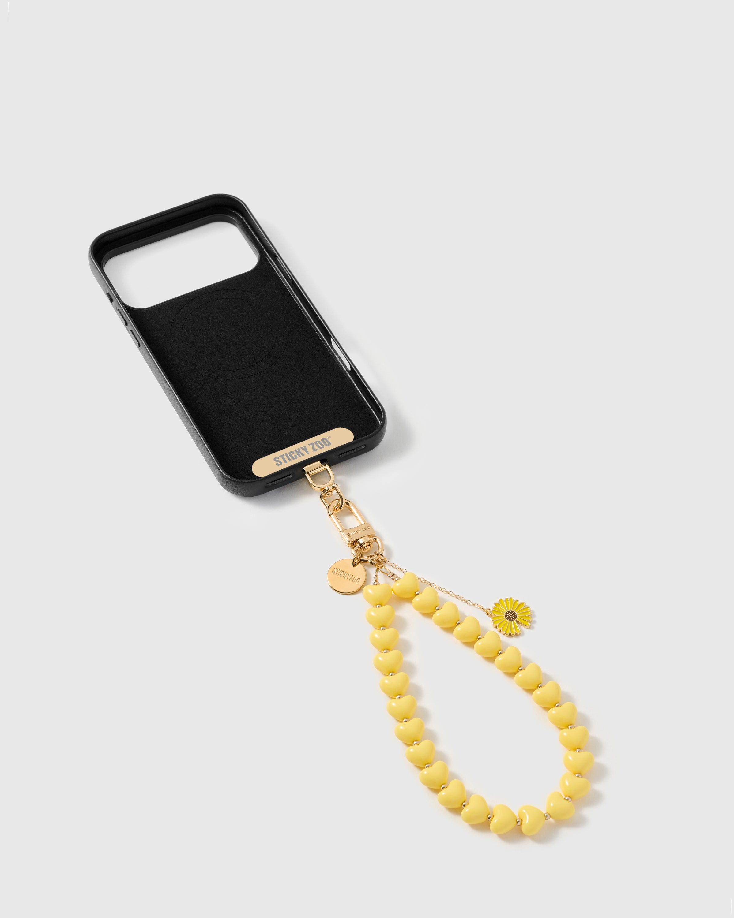 Phone Strap Card tucked inside phone case with lemon daisy heart strap attached — universal fit