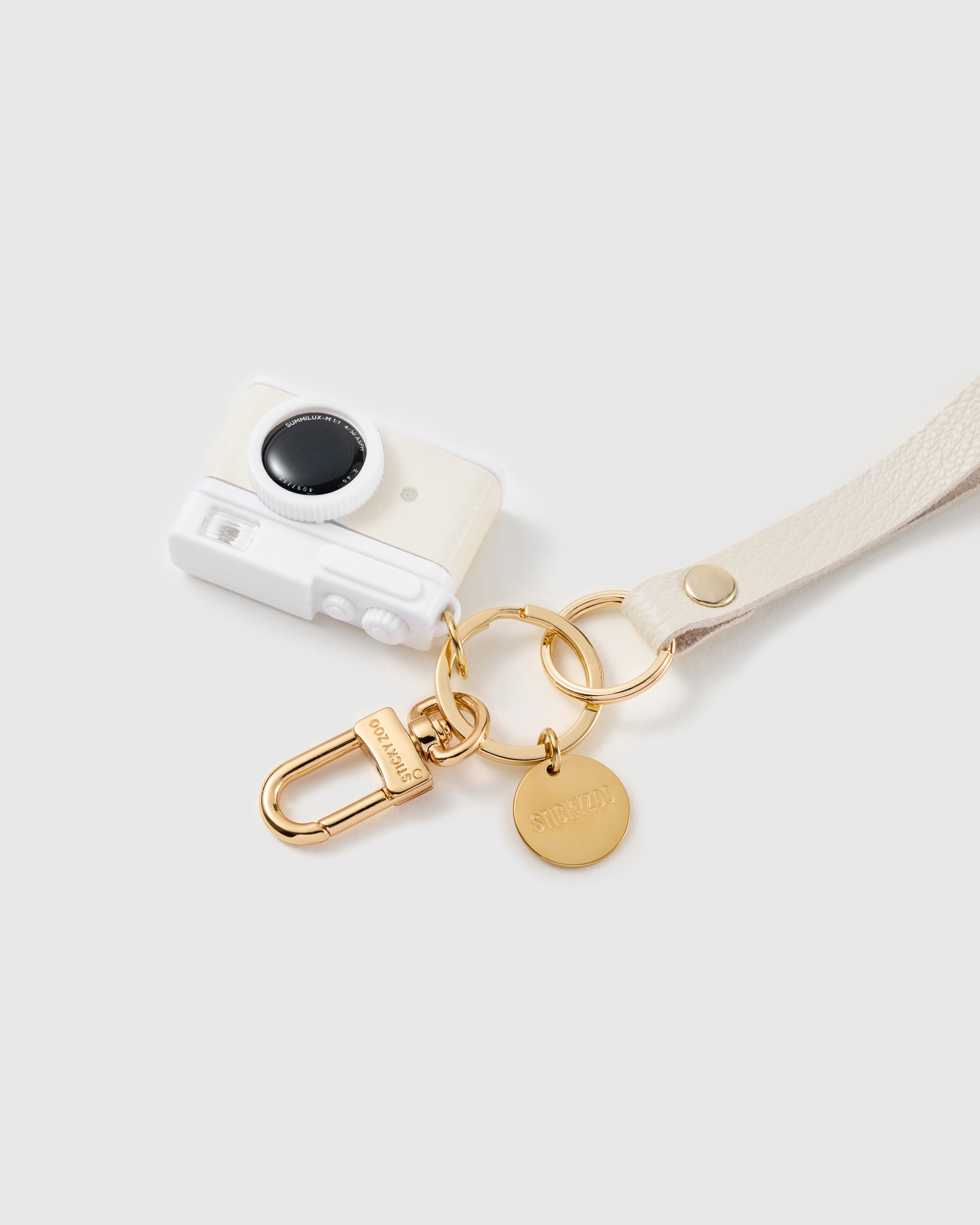 Ivory lens leather phone strap clipped to a phone case showing the hands-free wrist loop in use