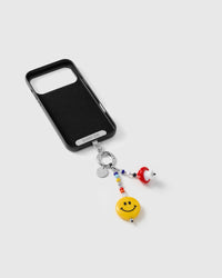 Inside of black phone case showing STICKYZOO Phone Strap Card attachment with charm hanging below