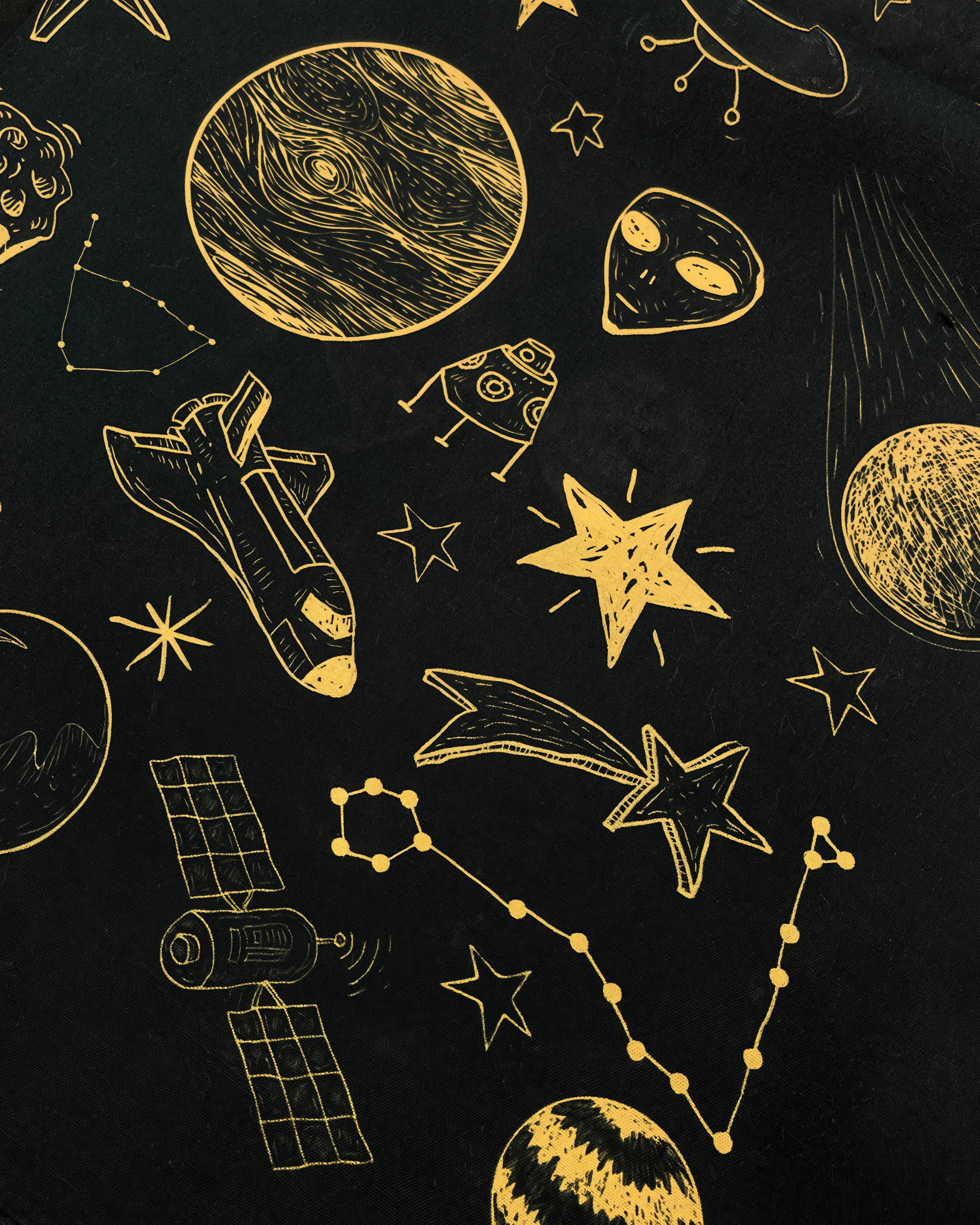 Close-up of the hand-illustrated rocket, alien and satellite motifs in gold on pure silk