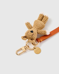 Tiny bunny leather phone strap clipped to a phone case showing the hands-free wrist loop in use