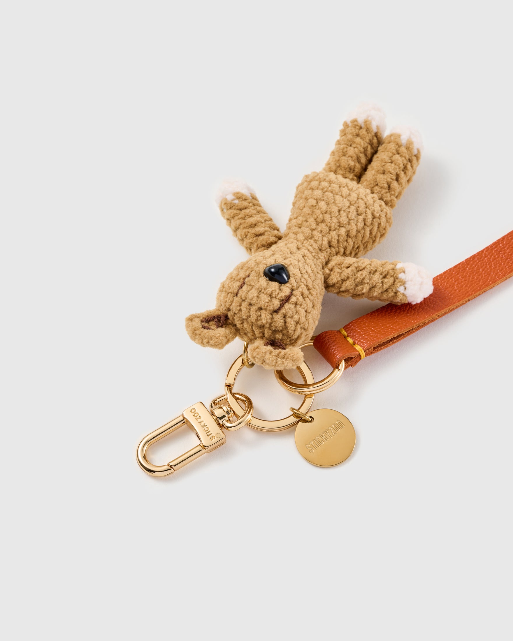 Tiny bunny leather phone strap clipped to a phone case showing the hands-free wrist loop in use