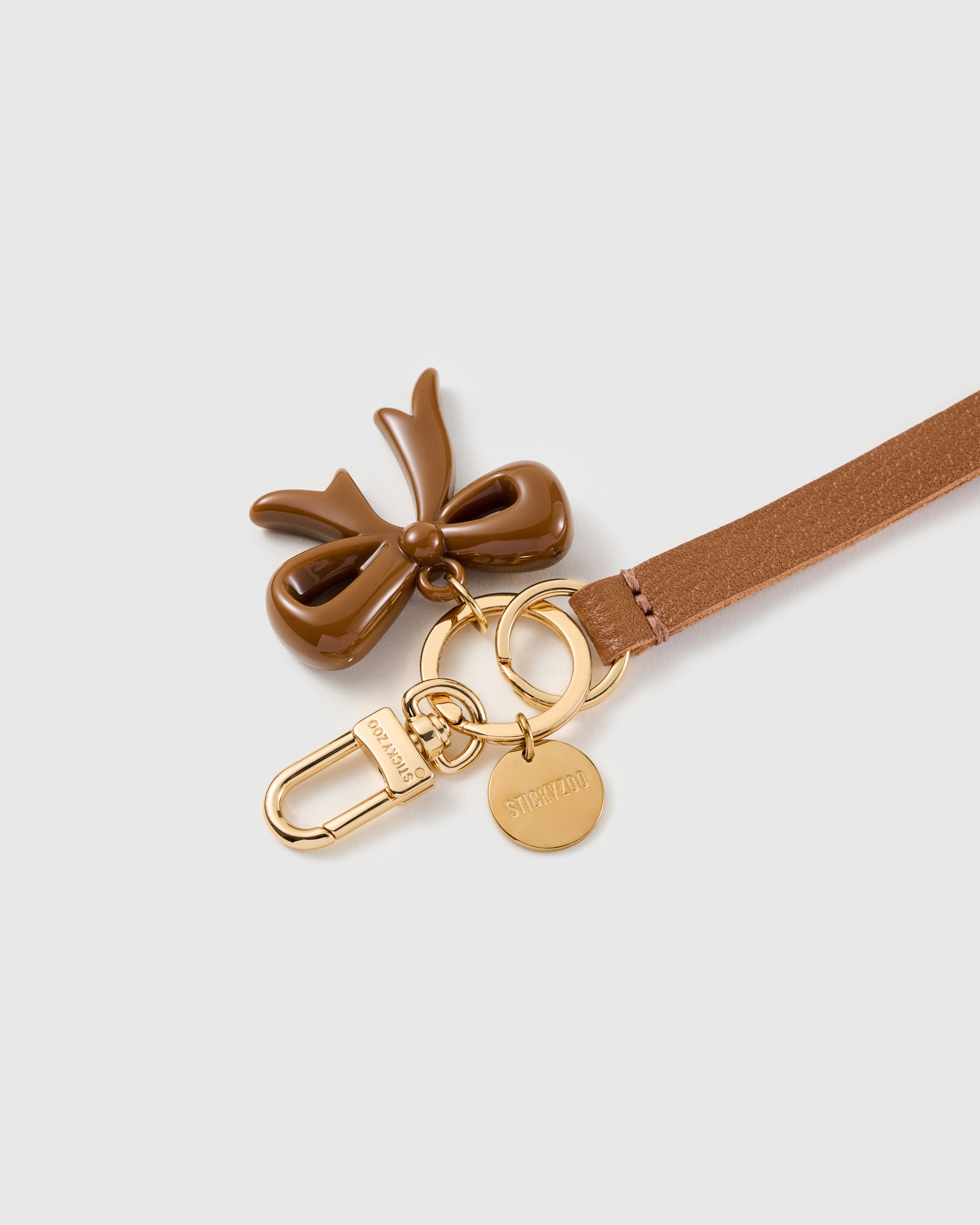 Hazel bow leather phone strap clipped to a phone case showing the hands-free wrist loop in use