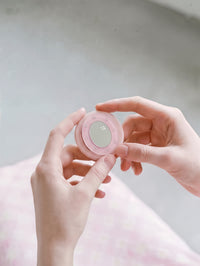 Close-up of the pink acrylic-resin pop-grip with a mirrored centre and a studded ring