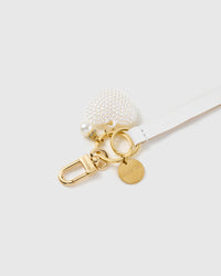 Pearl heart leather phone strap clipped to a phone case showing the hands-free wrist loop in use