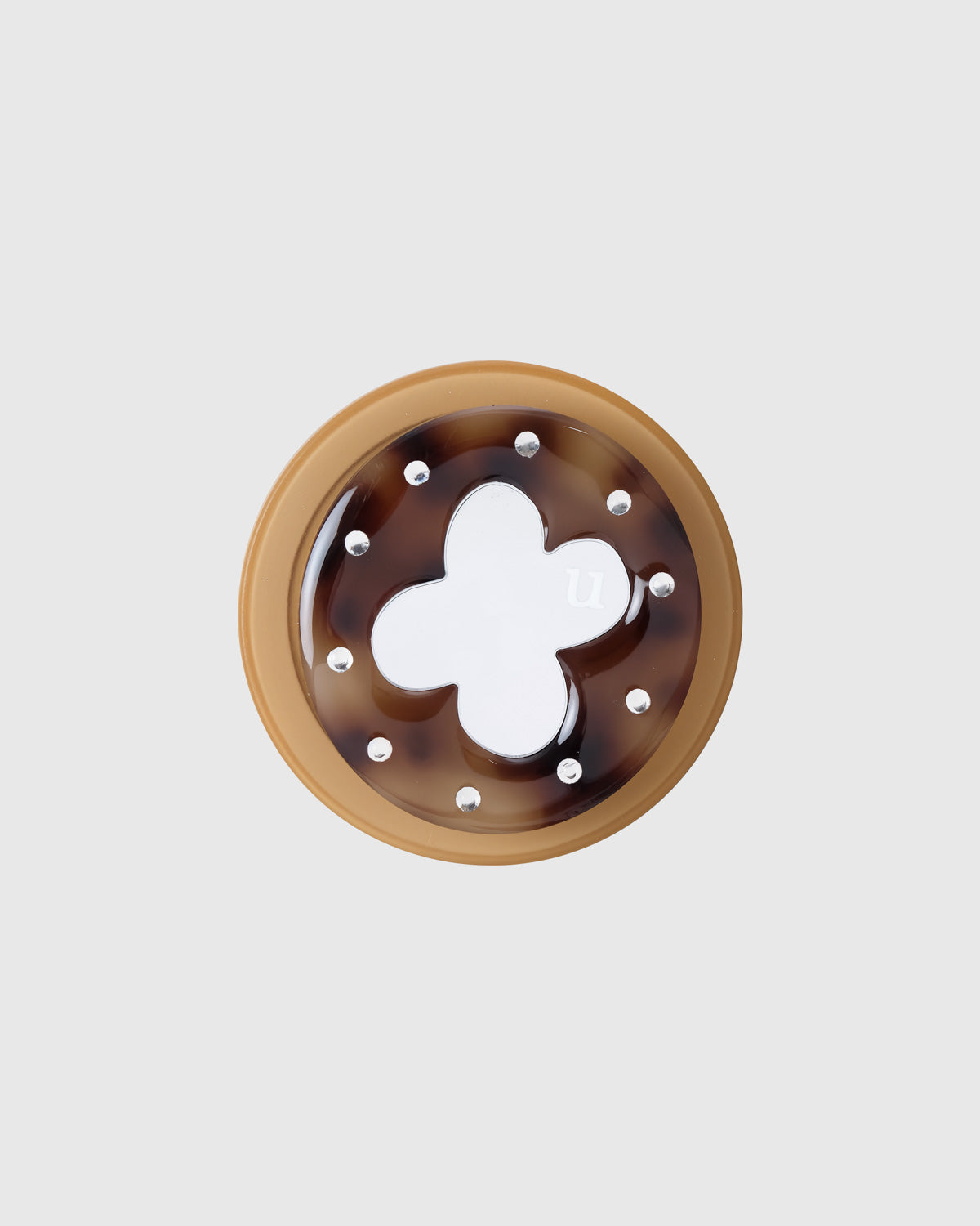 Close-up of the tortoiseshell acrylic-resin grip with a silver four-leaf clover ringed by clear gem studs