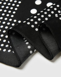 Close-up of the two-scale white polka dot print on black silk showing the archival ink density
