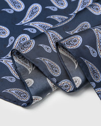 Folded edge of the navy boteh silk scarf showing the cornflower paisley and silk finish