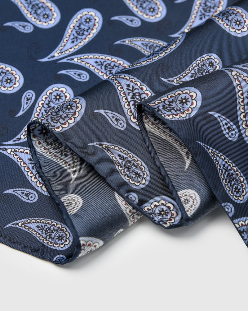 Folded edge of the navy boteh silk scarf showing the cornflower paisley and silk finish