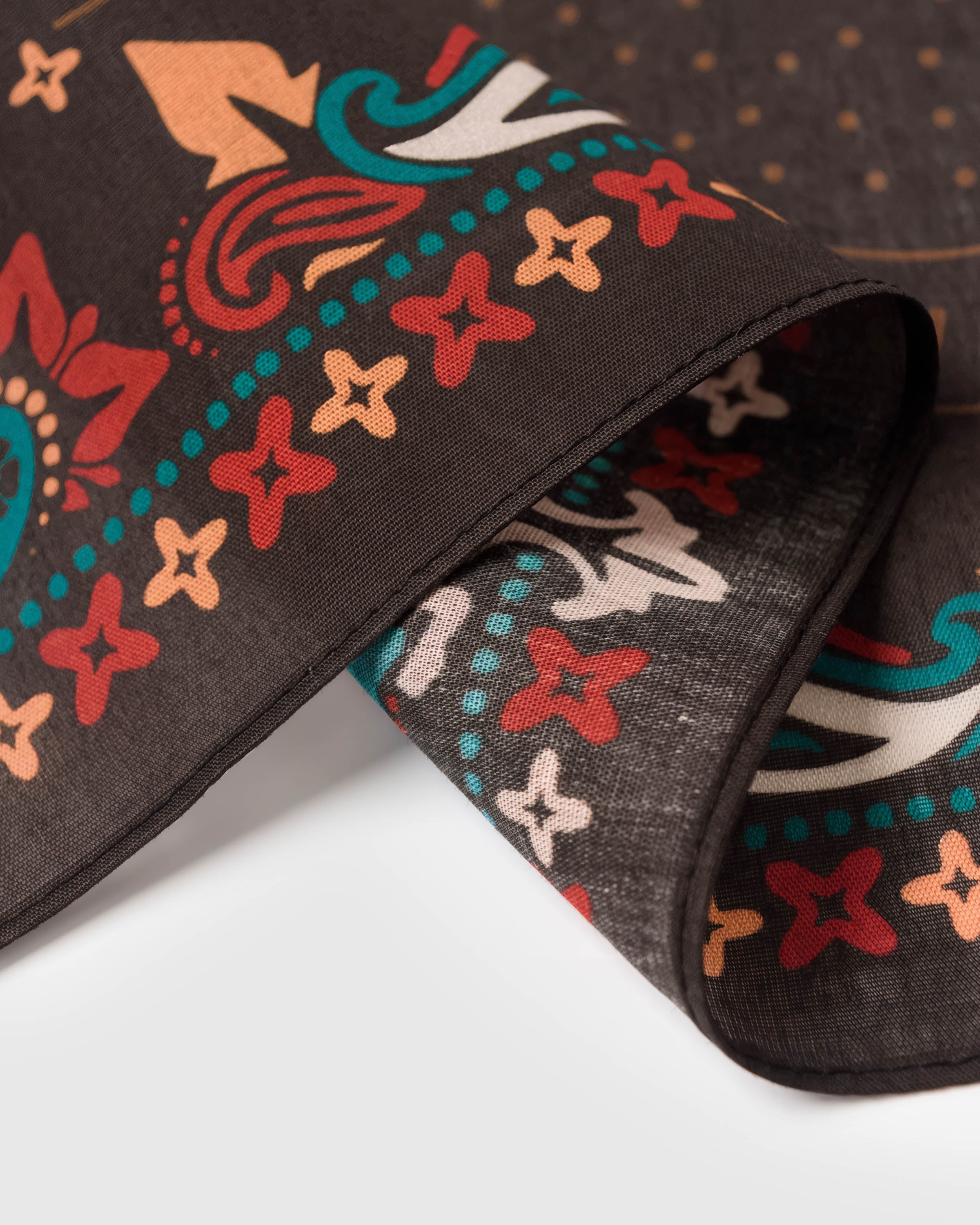 Close-up of the hand-illustrated teal and red paisley border on the calavera dance silk scarf