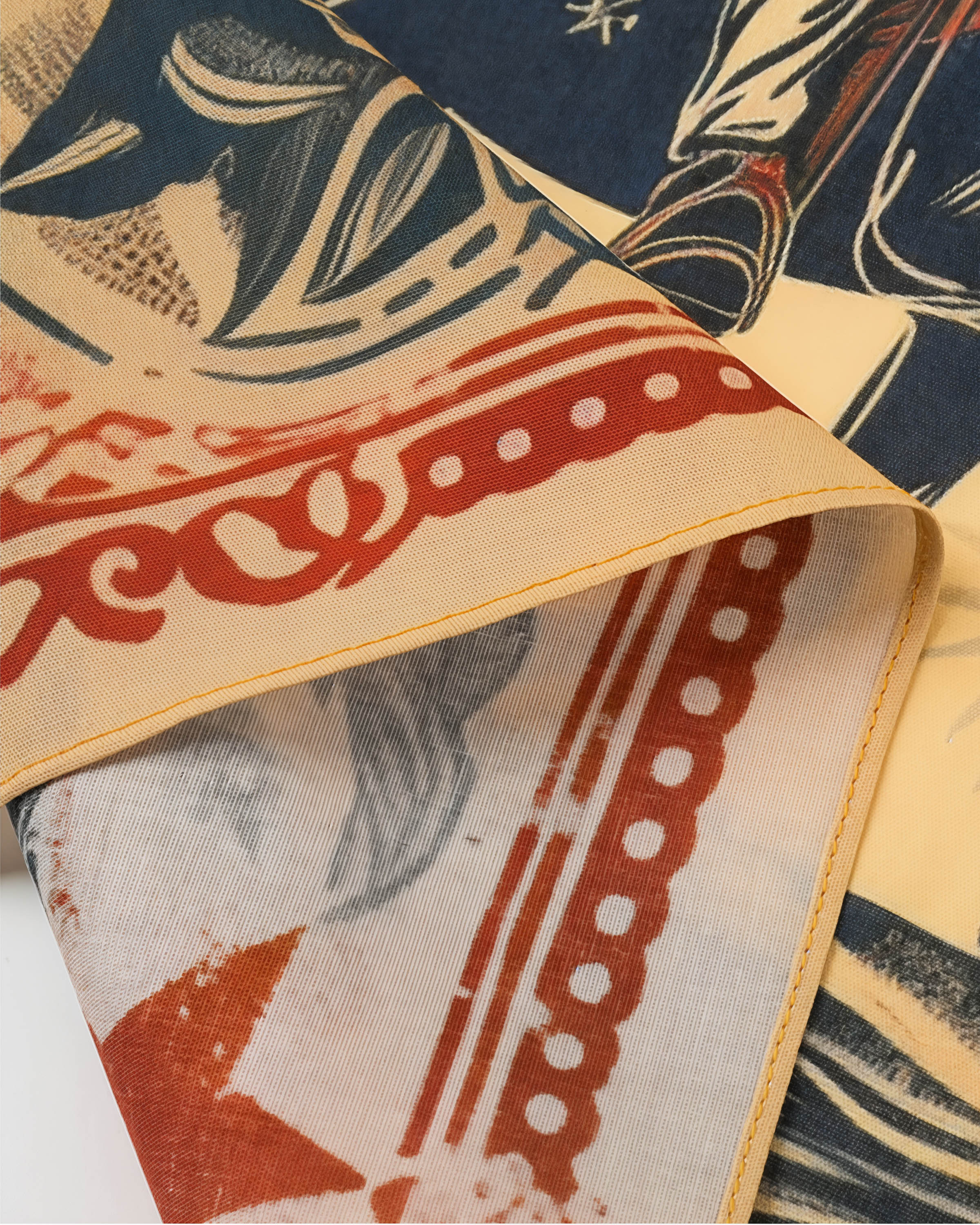 Close-up of the scalloped red-ochre border on the cowgirl rider silk scarf showing the silk weave