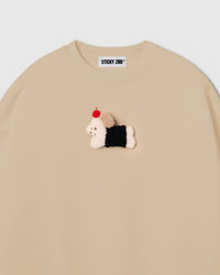 Close-up of plush dachshund in black coat with red apple on cream cotton showing soft tonal contrast