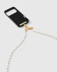 White faux-pearls and gold-tone beads trailing from a black phone case, the gold dual clasp and disc resting near the base.