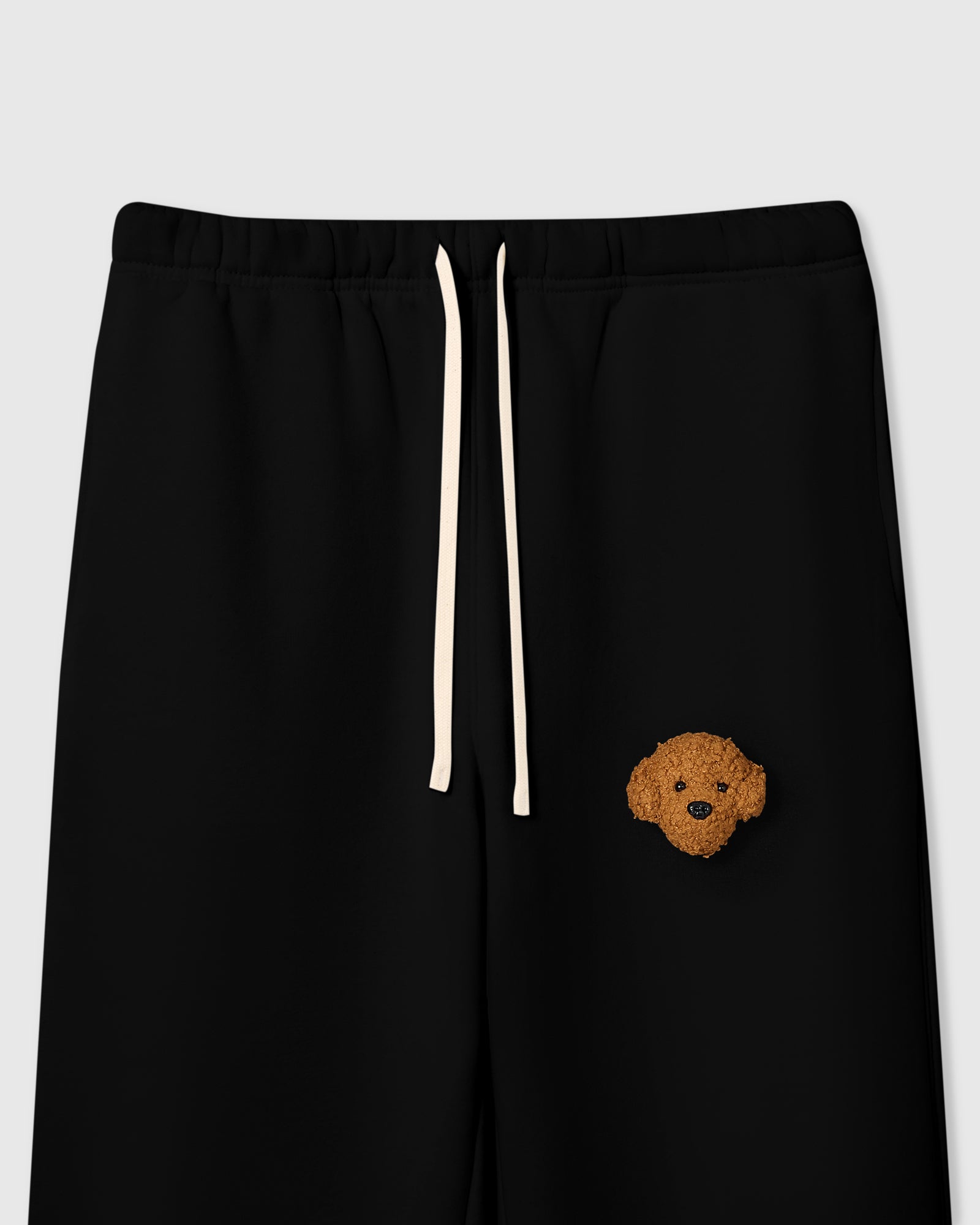 {{Not printed — stitched}} Close-up of plush poodle face on black 350gsm cotton showing curly dimensional texture