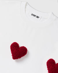 Model wearing STICKYZOO Triple Heart T-Shirt in white showing dropped shoulders and heart placement