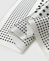 Close-up of the ivory silk edges showing the two-scale black polka dot print in archival ink