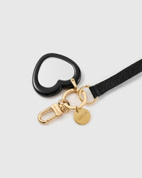 Mirror heart leather phone strap clipped to a phone case showing the hands-free wrist loop in use