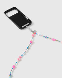 Silver-tone clasp and engraved disc joining a black phone case to the pink flower, heart and turquoise beaded strap as it drapes down.