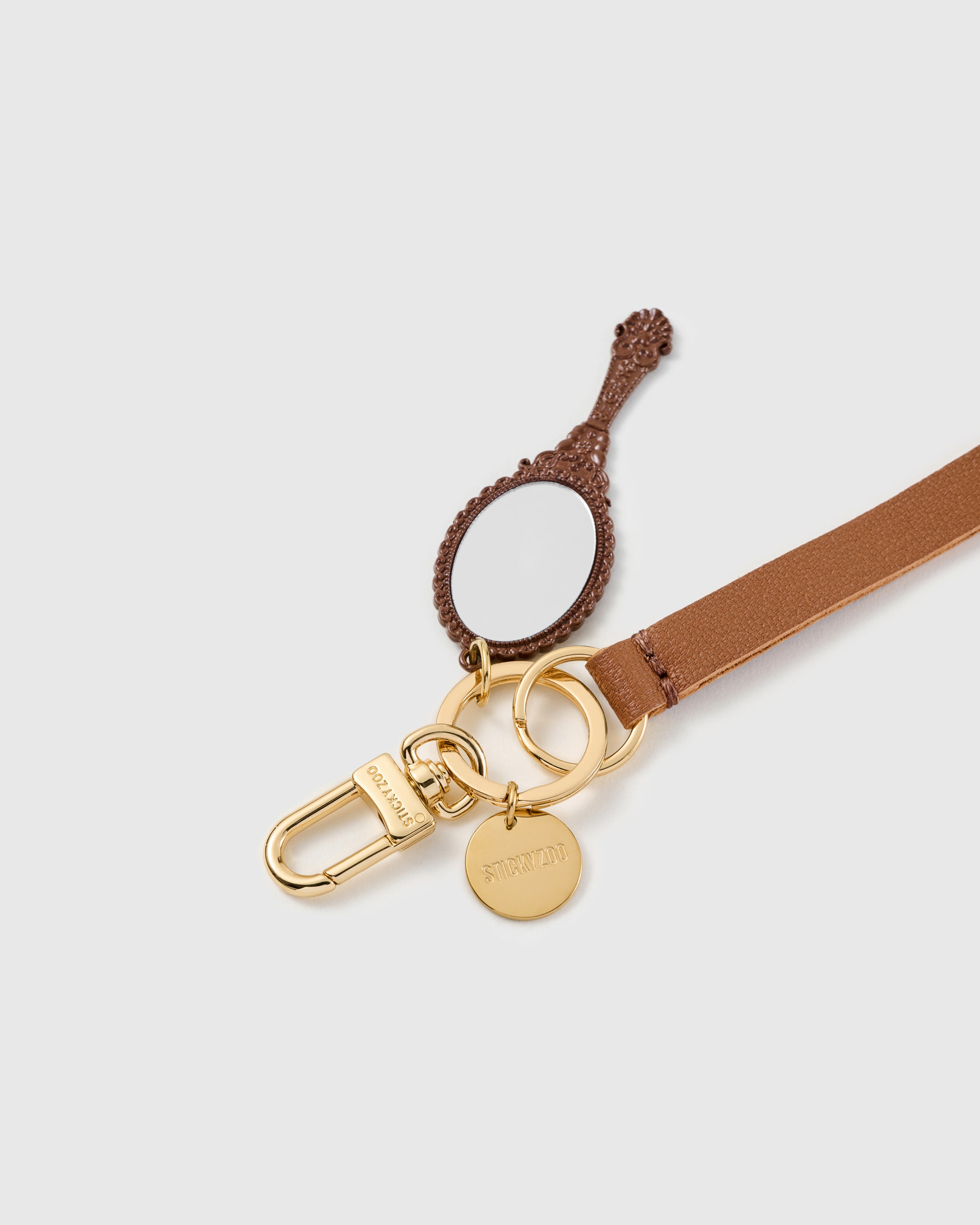 Heirloom mirror leather phone strap clipped to a phone case showing the hands-free wrist loop in use