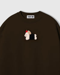 Close-up of plush dachshund in black coat with red apple on brown cotton showing tonal warmth and layered texture