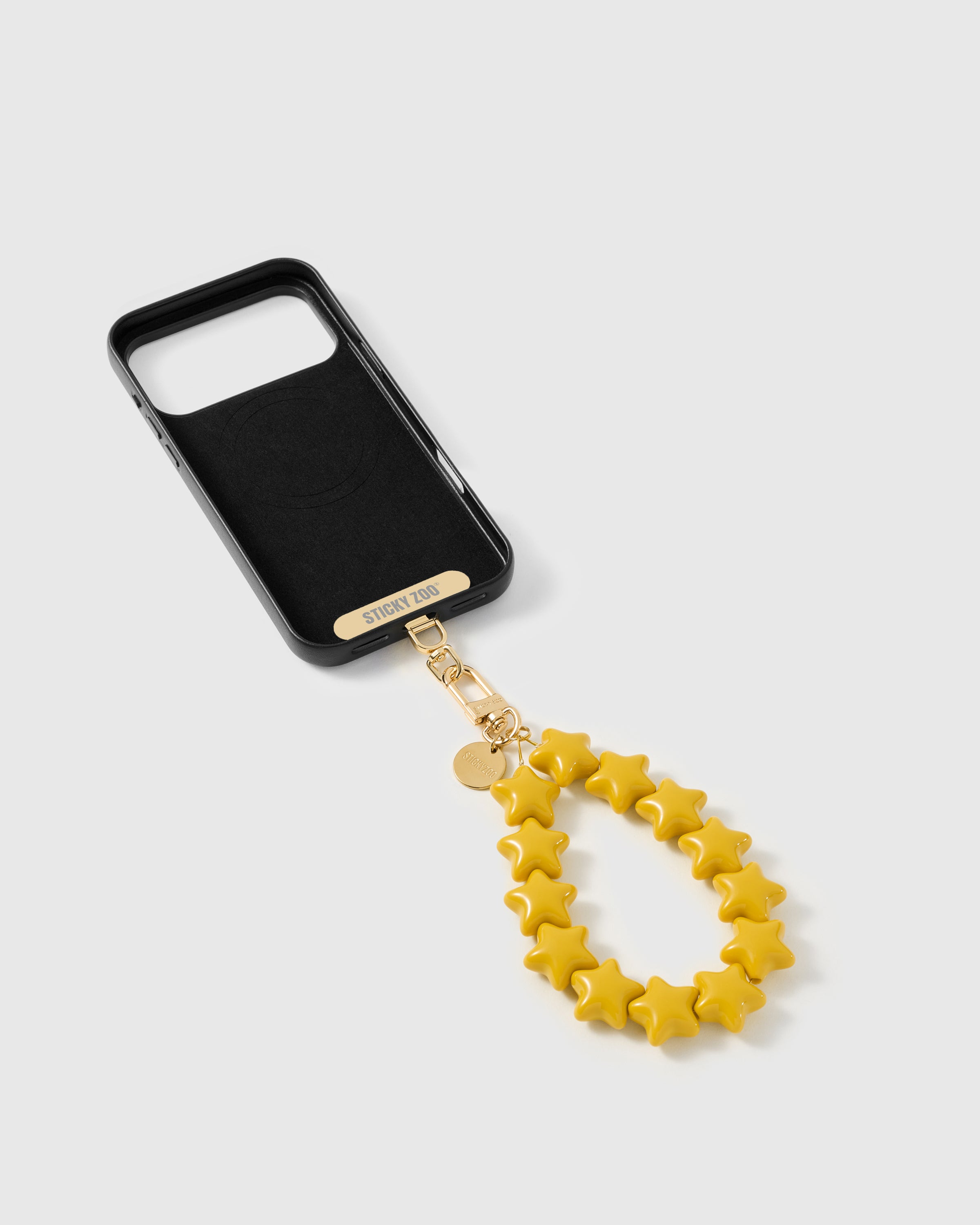 Phone Strap Card tucked inside phone case with honey-gold star strap attached — universal fit