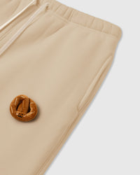 Model wearing STICKYZOO Double Croissant Sweatpants in cream showing elastic drawstring waist and relaxed fit