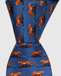 Raised thread, not print Royal Tiger Tie knot close-up showing embroidered tiger detail and silk texture on cobalt blue