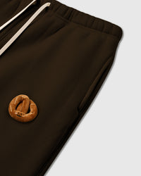 Model wearing STICKYZOO Double Croissant Sweatpants in brown showing elastic drawstring waist
