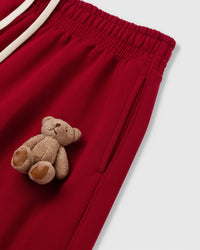 Close-up of plush bear applique on red heavyweight fleece showing hand-sewn construction