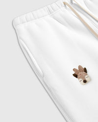 Detail view of hand-stitched woodland plush appliques on white cotton showing dimensional depth