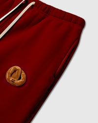 Model wearing STICKYZOO Double Croissant Sweatpants in red showing elastic drawstring waist and relaxed proportions