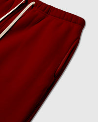 Detail of elastic waistband with cream drawstring on red premium cotton sweatpants showing heavyweight construction