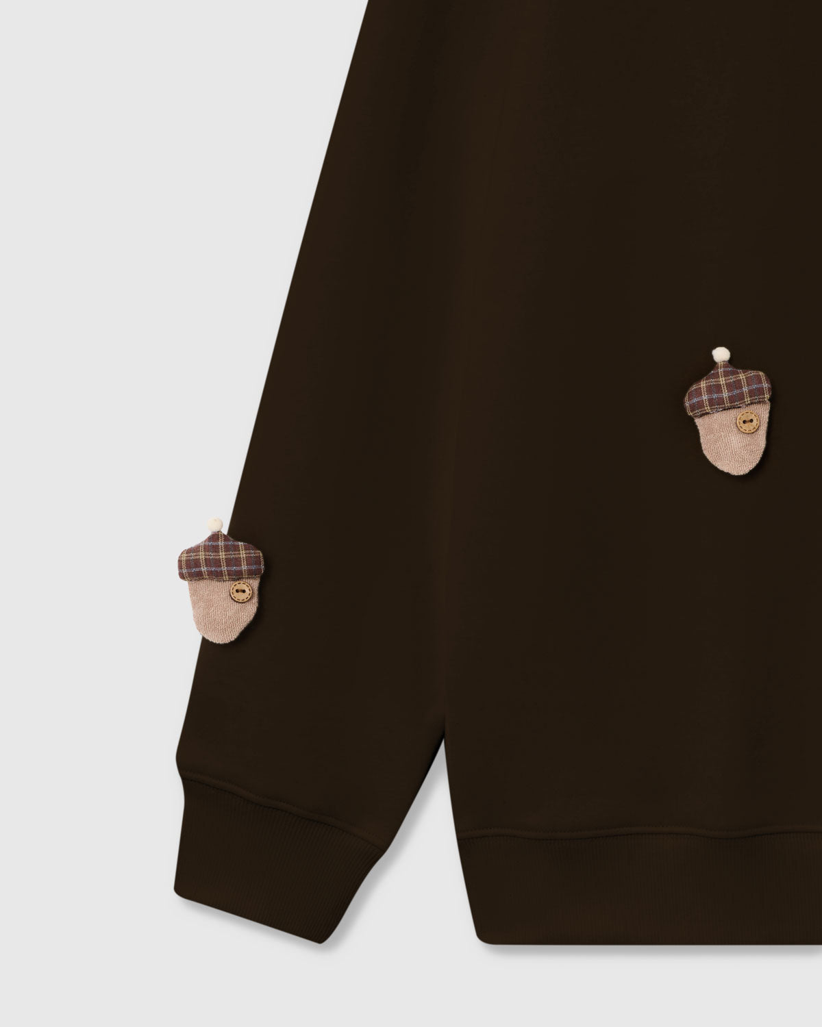 {{Rated 4.9 by thousands}} Detail of hand-stitched plush acorn with tartan cap and button center on brown cotton sweatshirt