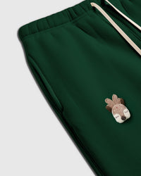 Close-up of plaid acorn plush applique on white sweatpant showing layered patterned construction