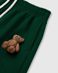 Close-up of plush bear applique on forest green heavyweight fleece showing hand-sewn construction