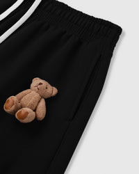 Close-up of plush bear applique on black heavyweight fleece showing hand-sewn construction