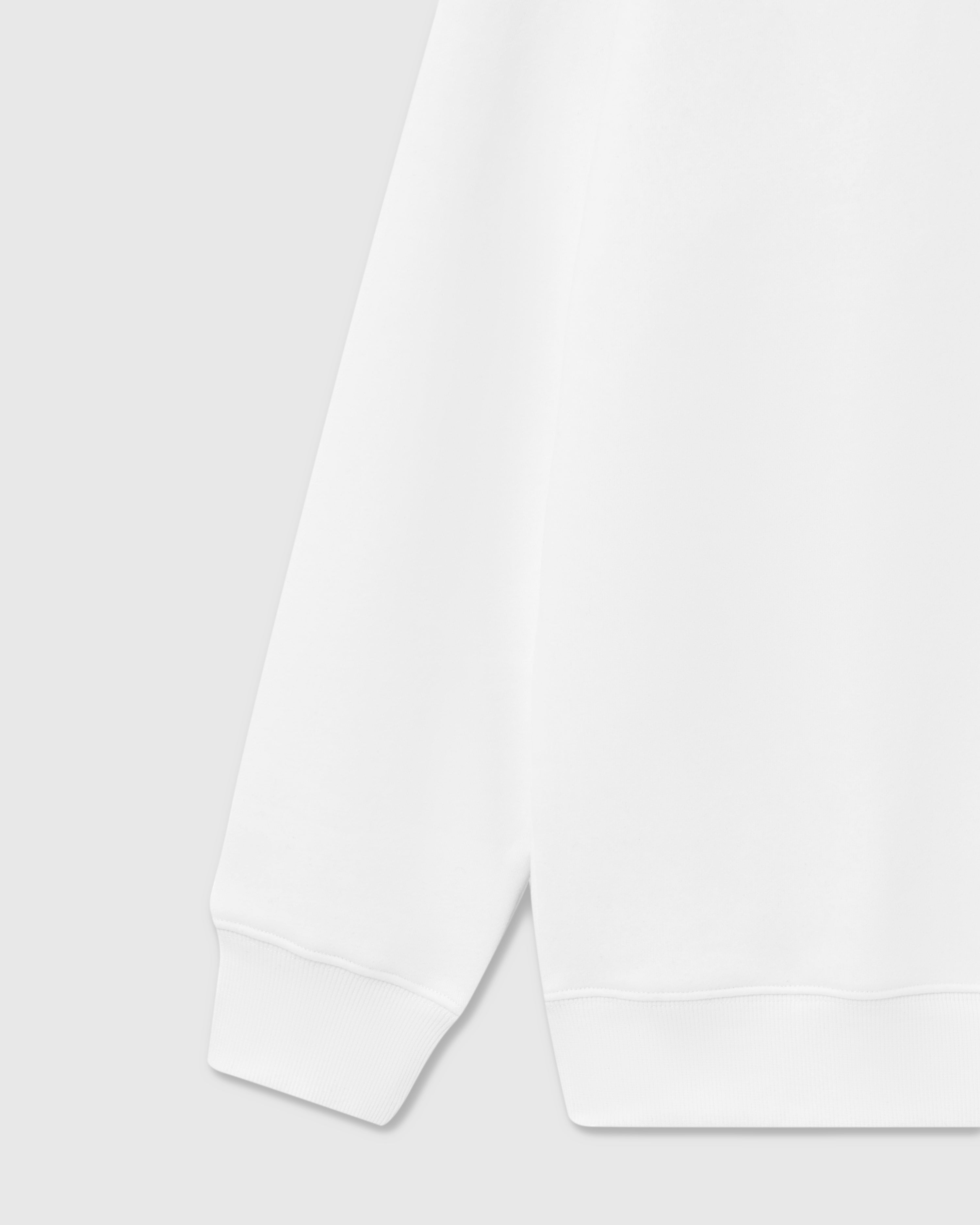 {{Ribbed cuffs, built solid}} Detail of ribbed cuff and hem construction on white premium cotton sweatshirt showing clean finishing
