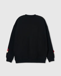 Back view of black Mushroom Sweatshirt showing clean seams with plush mushrooms peeking at sleeve cuffs