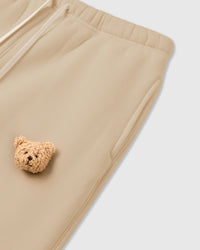 Detail of bear applique on STICKYZOO cream Sticky Bear Sweatpant showing tonal warmth