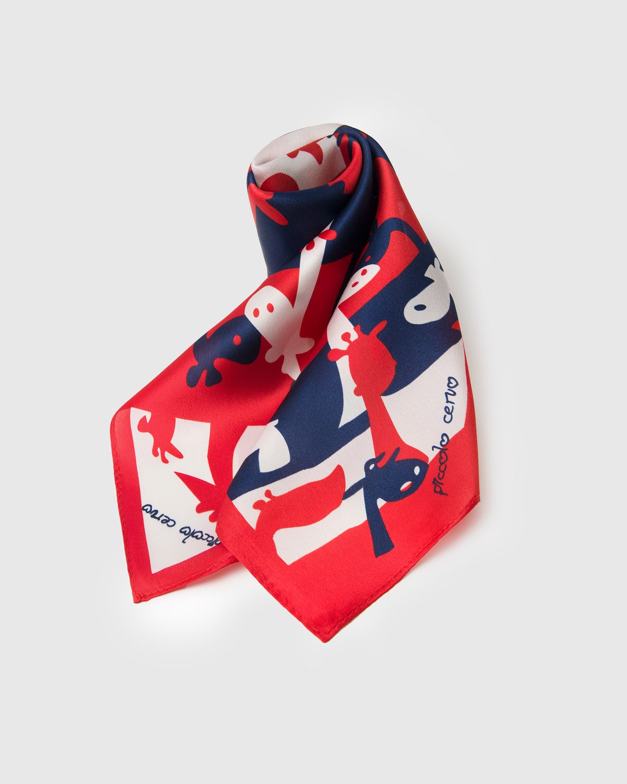 Silk scarf rolled to show the red, navy, and ivory bands and the slim cherry border meeting the print
```