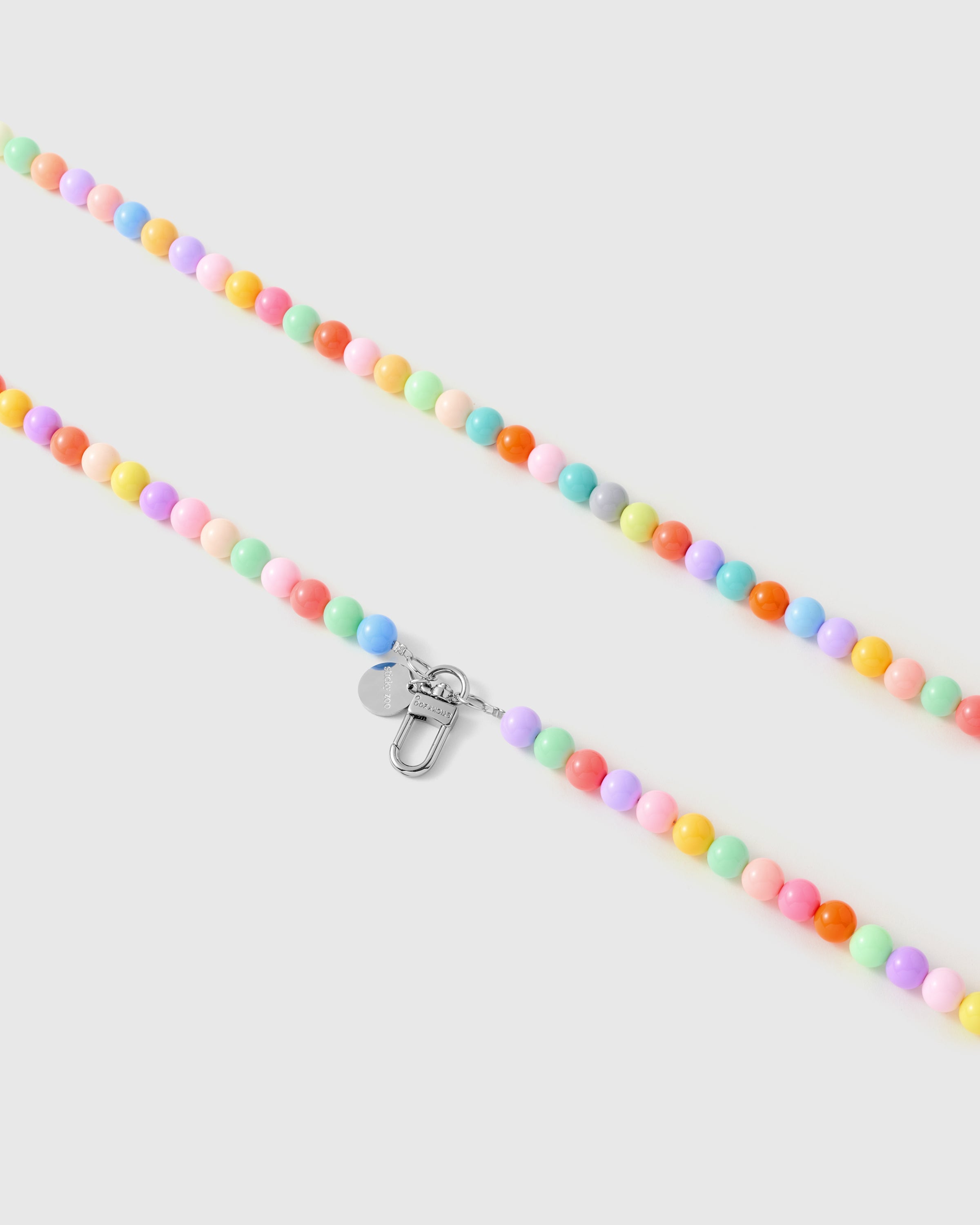 Silver-tone lobster clasp and engraved STICKYZOO charm disc on a handmade pastel beaded strap.