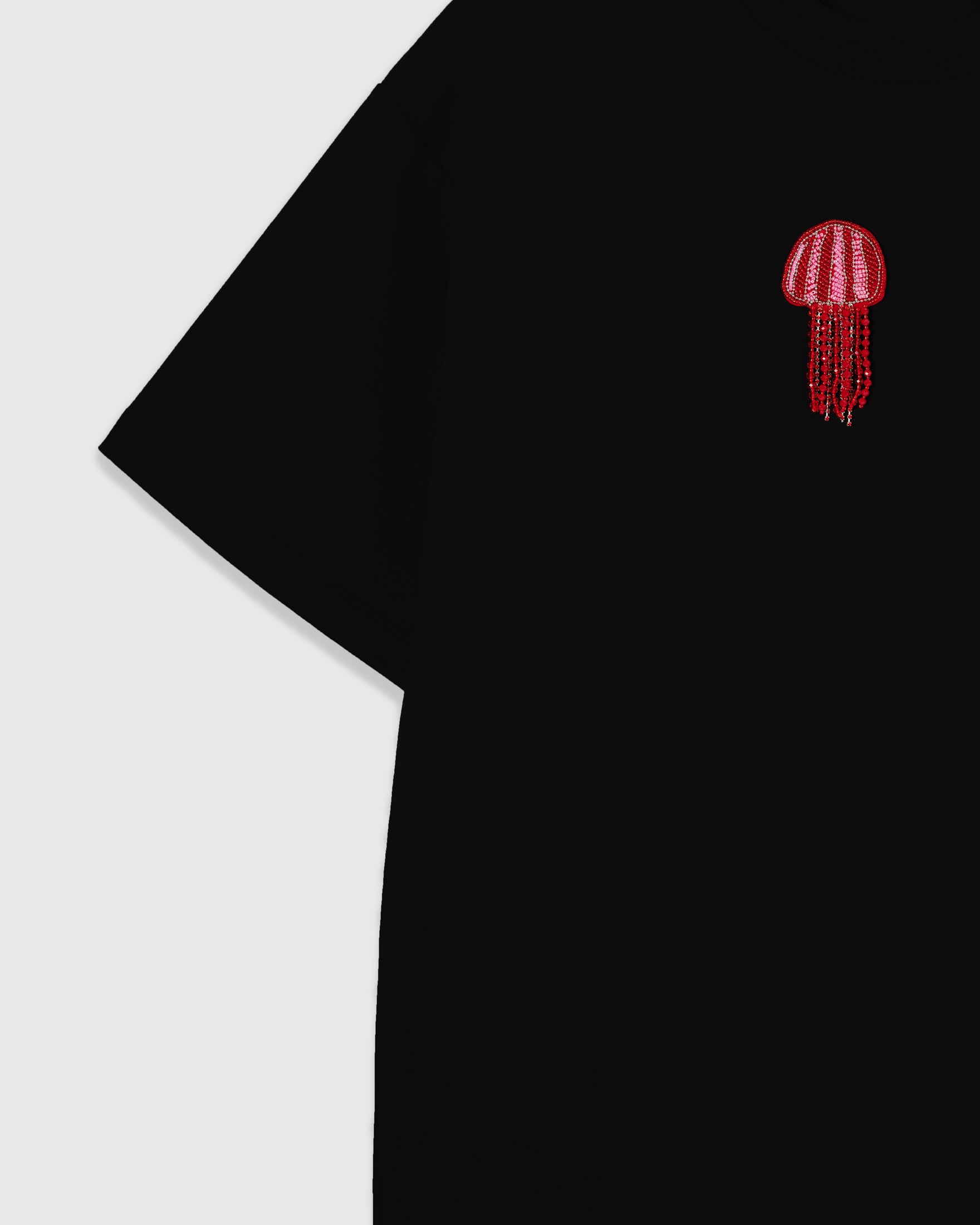Striped sequin jellyfish bell with hanging glass-bead tentacles sewn onto the black oversized tee