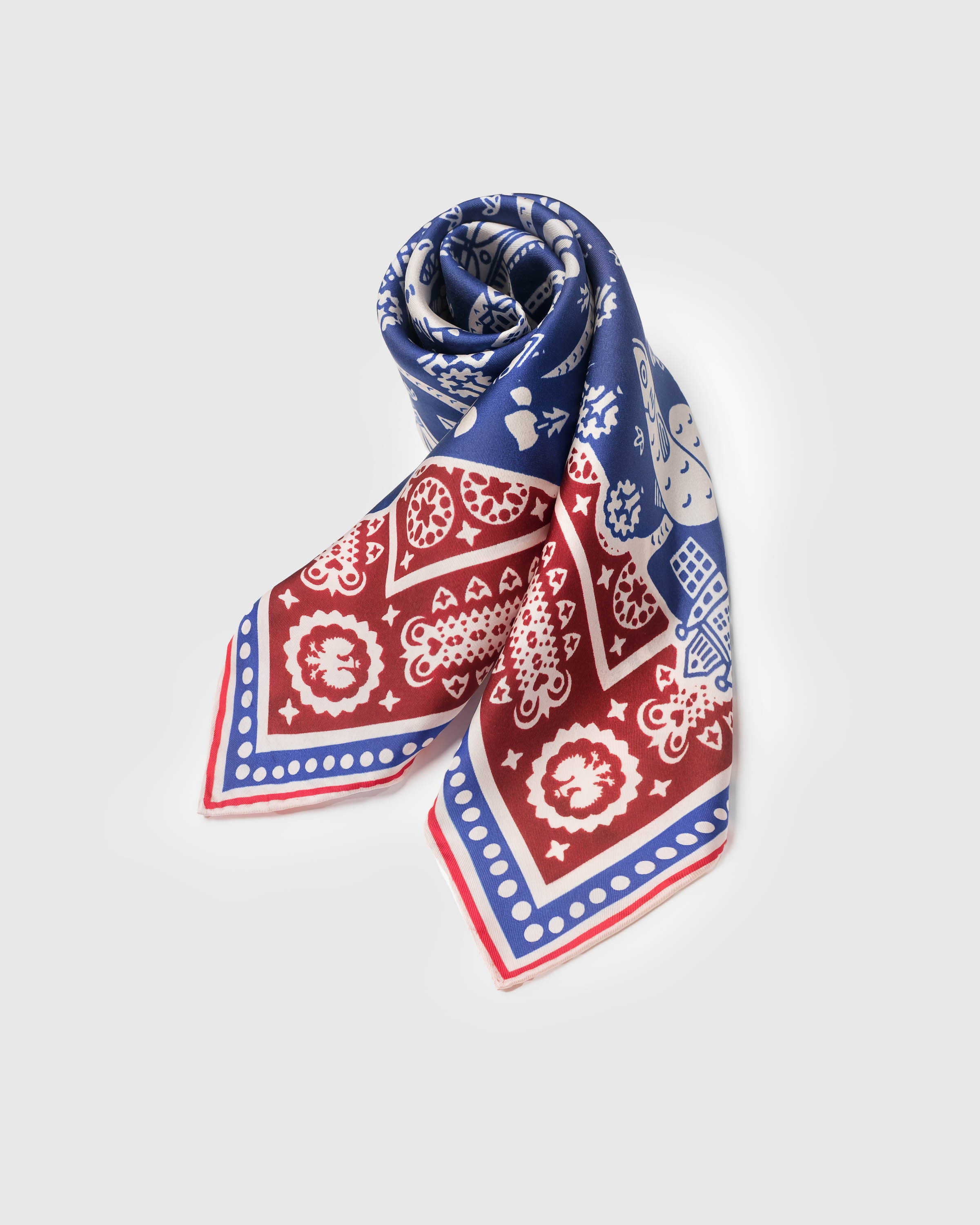 Folded storybook map silk scarf with the burgundy frame and cobalt field on display
```